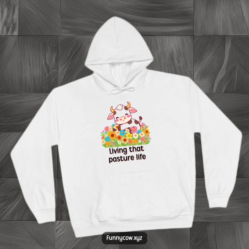 Funny hoodie illustrating a content cow gleefully rolling amidst a picturesque abundance of colorful flowers, a symbol of happiness.